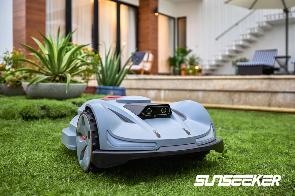 A robot lawn mower is sitting in the grass.